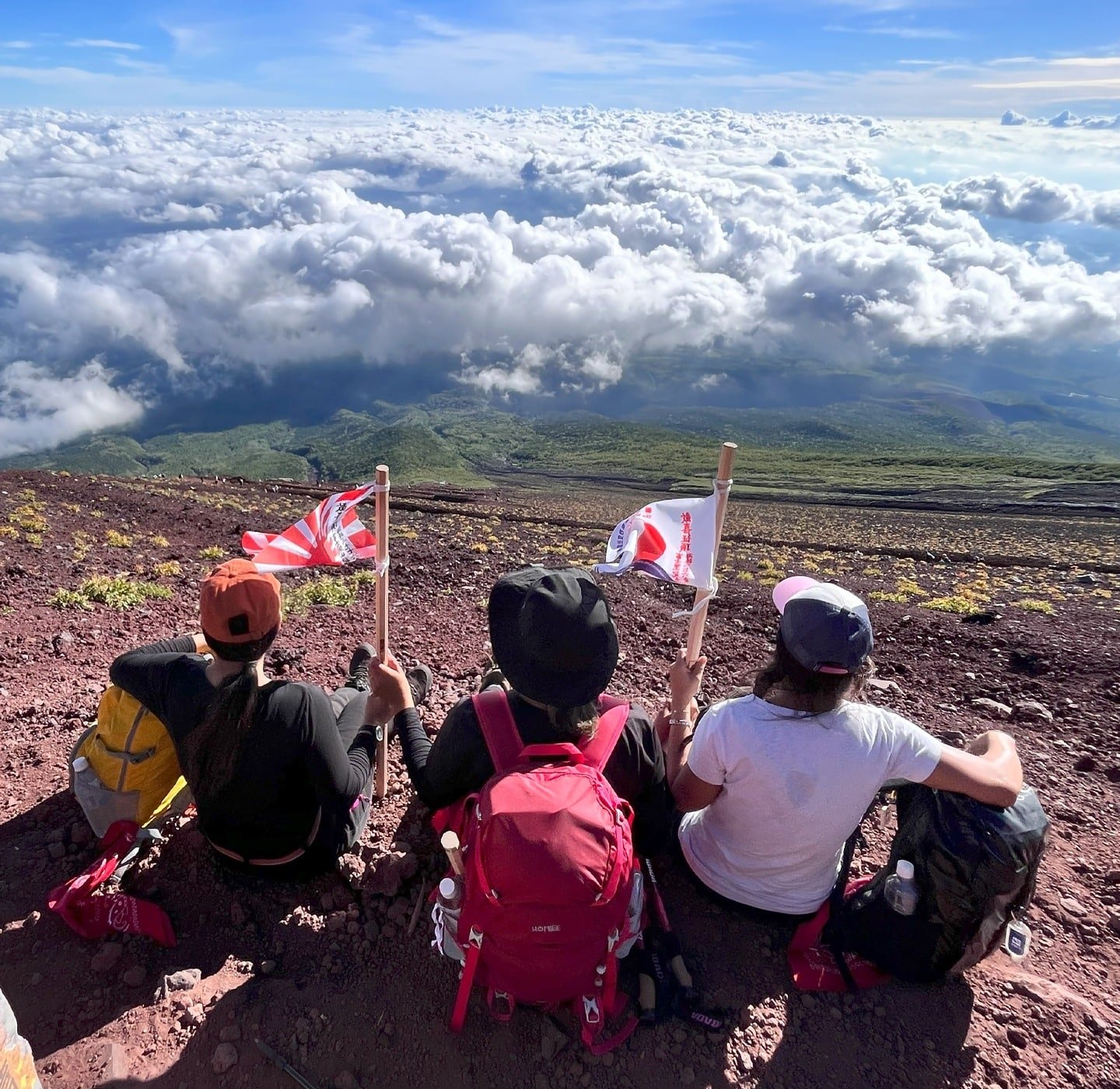 Três turistas apreciando a vista do Monte Fuji.