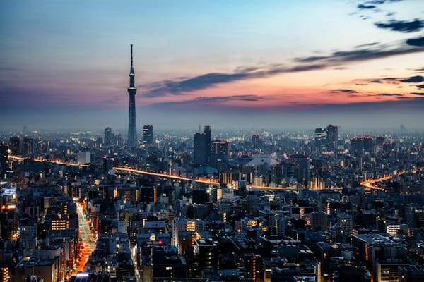Skyline de Tóquio no por do sol, com destaque para as luzes nas ruas e a silhueta da Tokyo Skytree.