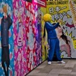 Uma pessoa vestindo azul e uma cabeça de passáro amarelo em Harajuku.