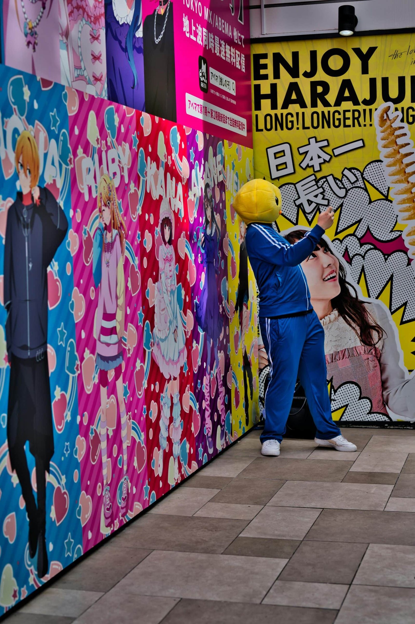 Uma pessoa vestindo azul e uma cabeça de passáro amarelo em Harajuku.