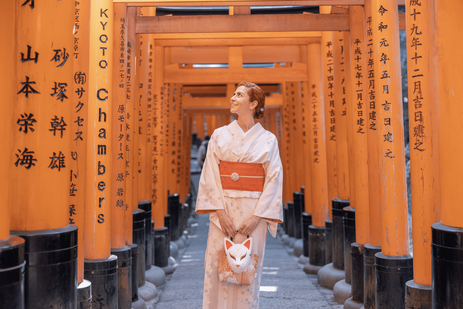 Kalu vestindo um kimono entre os Torii Gates em Fushimi Inari.