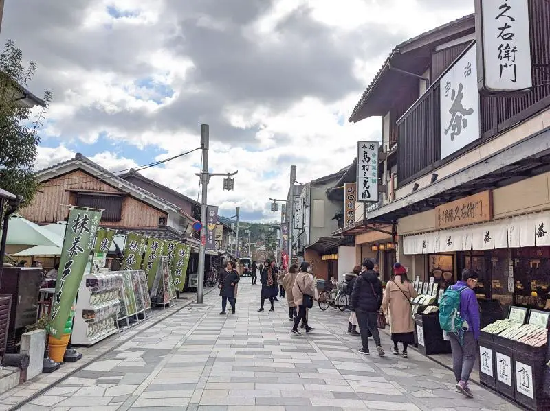 Uma vista da Omotesando Street, com diversas lojas e pessoas passeando.