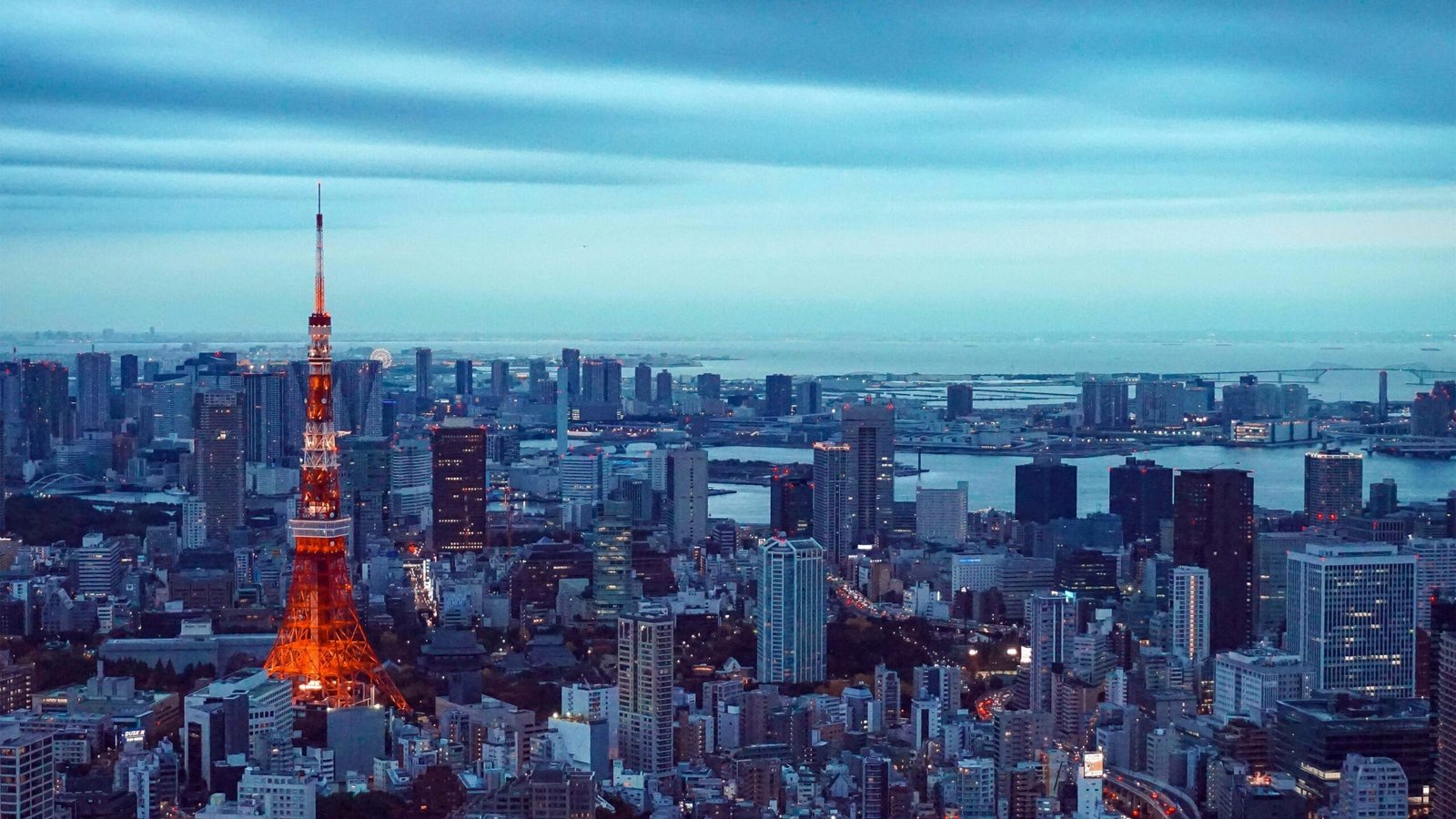Prédios em Tóquio, com a Tokyo Tower em destaque, com suas luzes vermelhas.